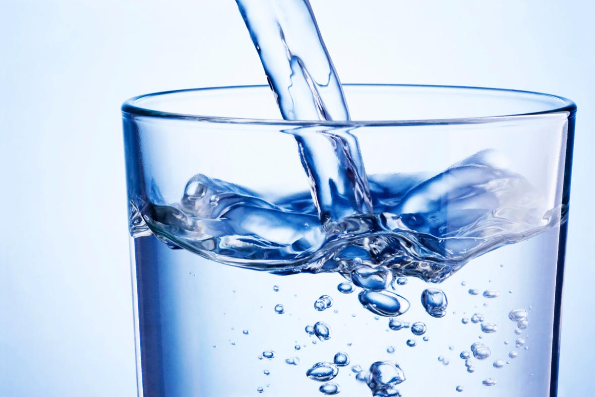 Clear, clean water being poured into a glass.